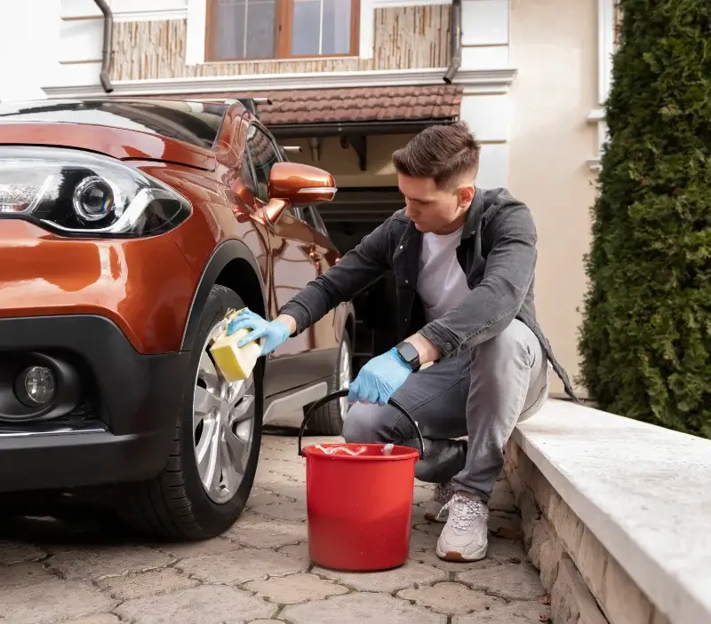 Lavage auto à domicile Conques-en-Rouergue : professionnel intervenant sur un véhicule